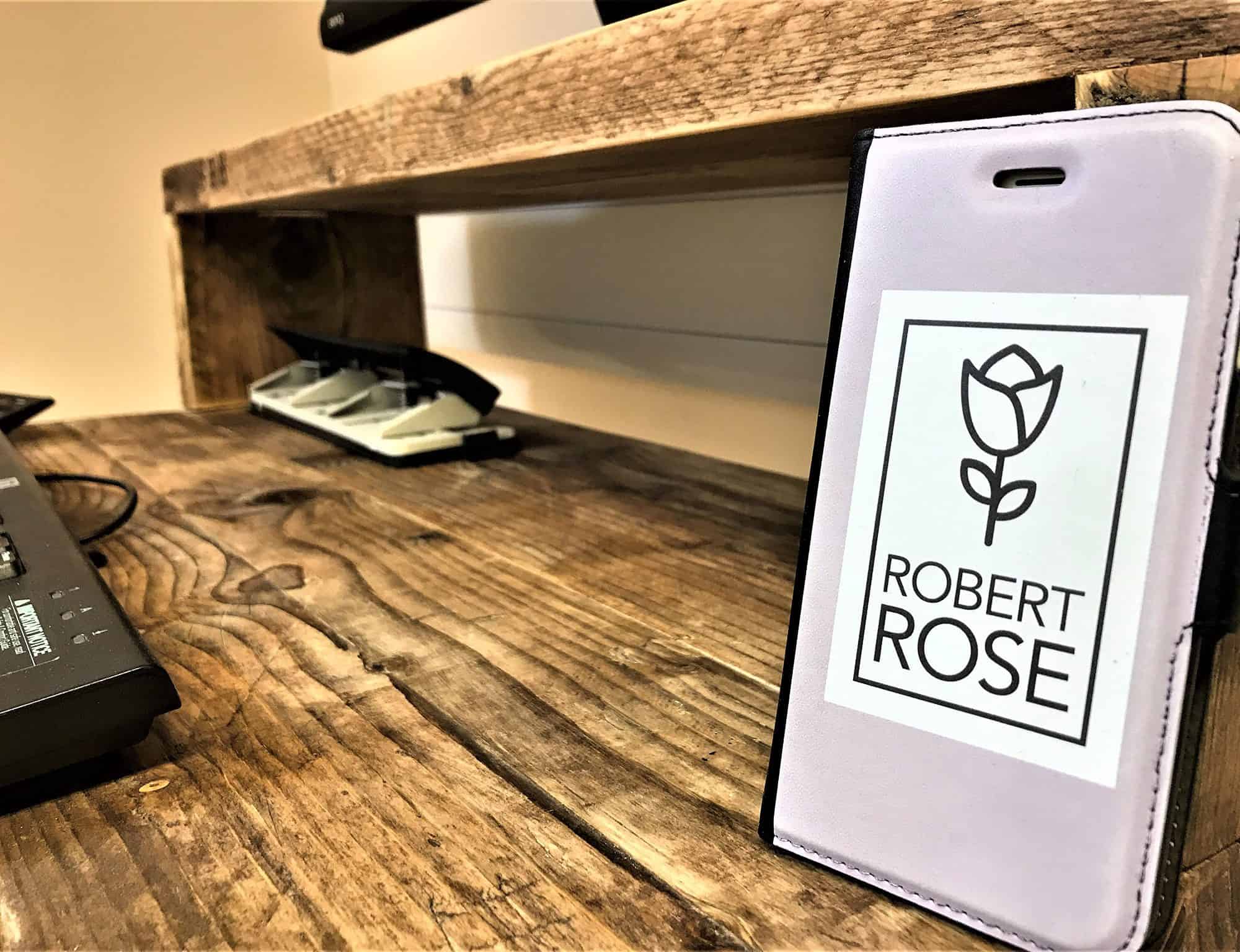 Reclaimed-wood desk and shelf beside a Robert Rose phone case