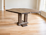 Akers hexagonal reclaimed wood dining table with twin wooden pedestal supports in a bright Scandinavian dining room.