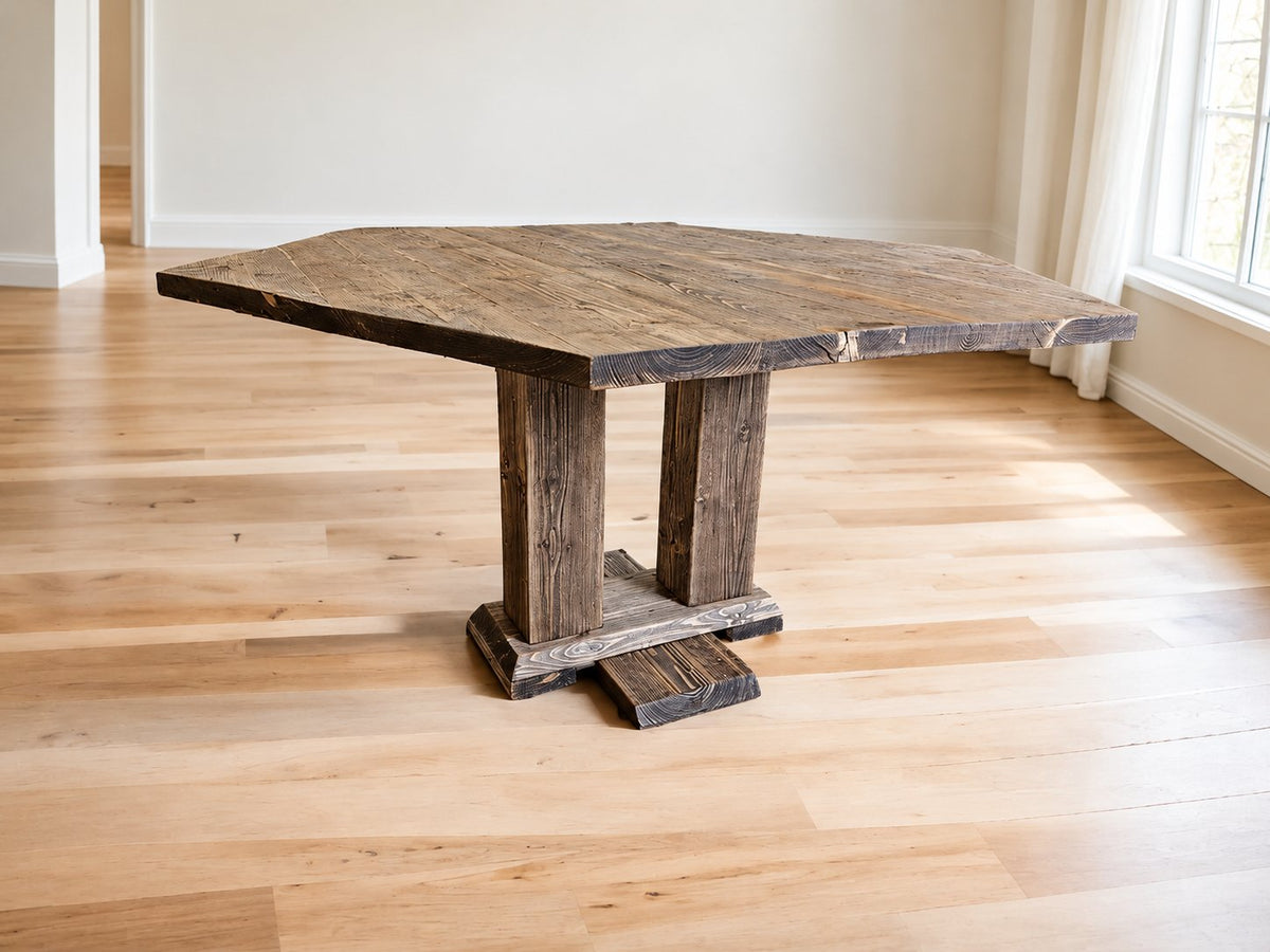Akers hexagonal reclaimed wood dining table with twin wooden pedestal supports in a bright Scandinavian dining room.