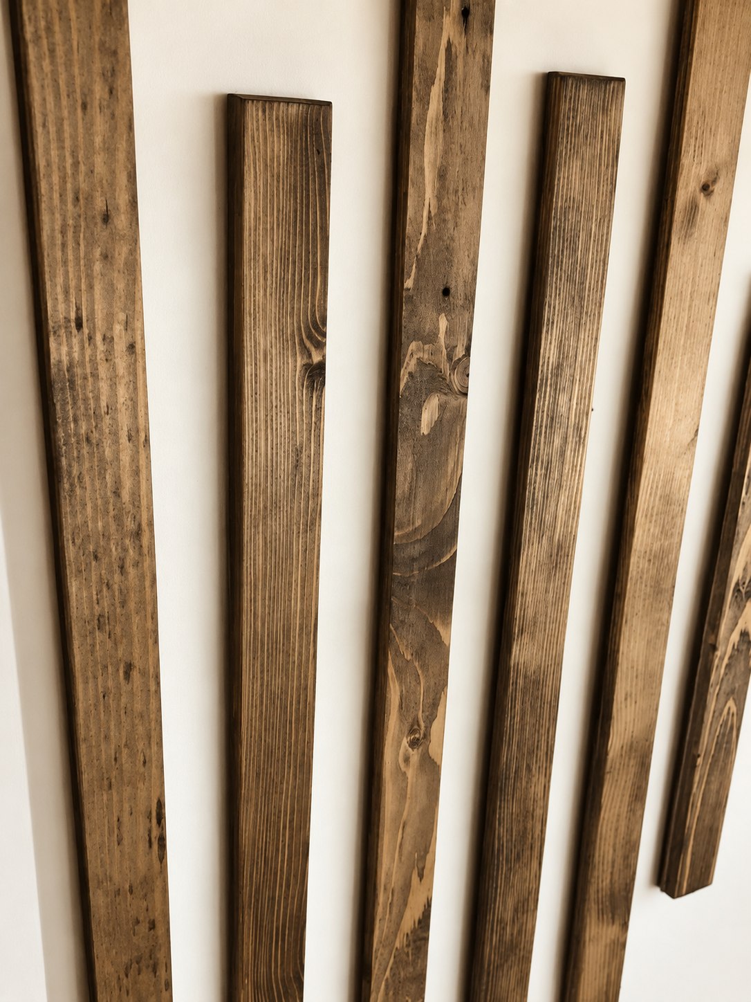 Chichester reclaimed wood wall slats with staggered lengths and natural weathered grain against a warm neutral wall.