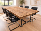 Portswood reclaimed wood boardroom table with scaffold-pipe legs, low metal stretchers and round floor plates in a warm Scandinavian room.