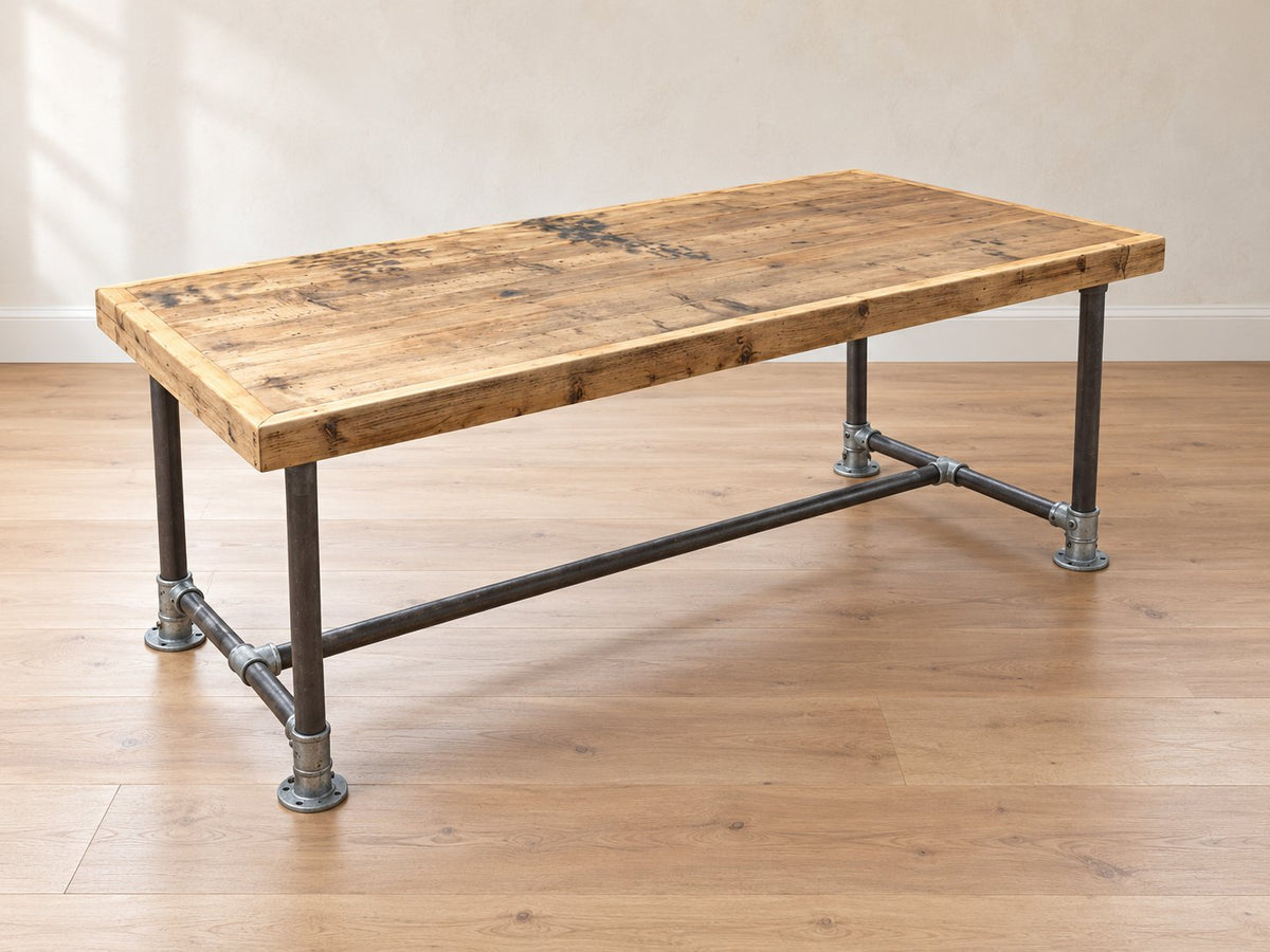 Robin reclaimed wood desk with scaffold-pipe legs and a thick framed tabletop in a bright Scandinavian room.
