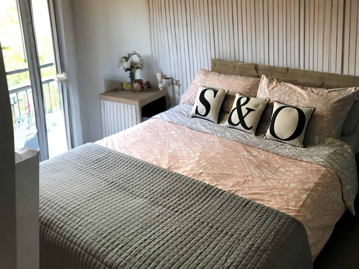 Industrial-style bed with a reclaimed-wood headboard in a modern bedroom.