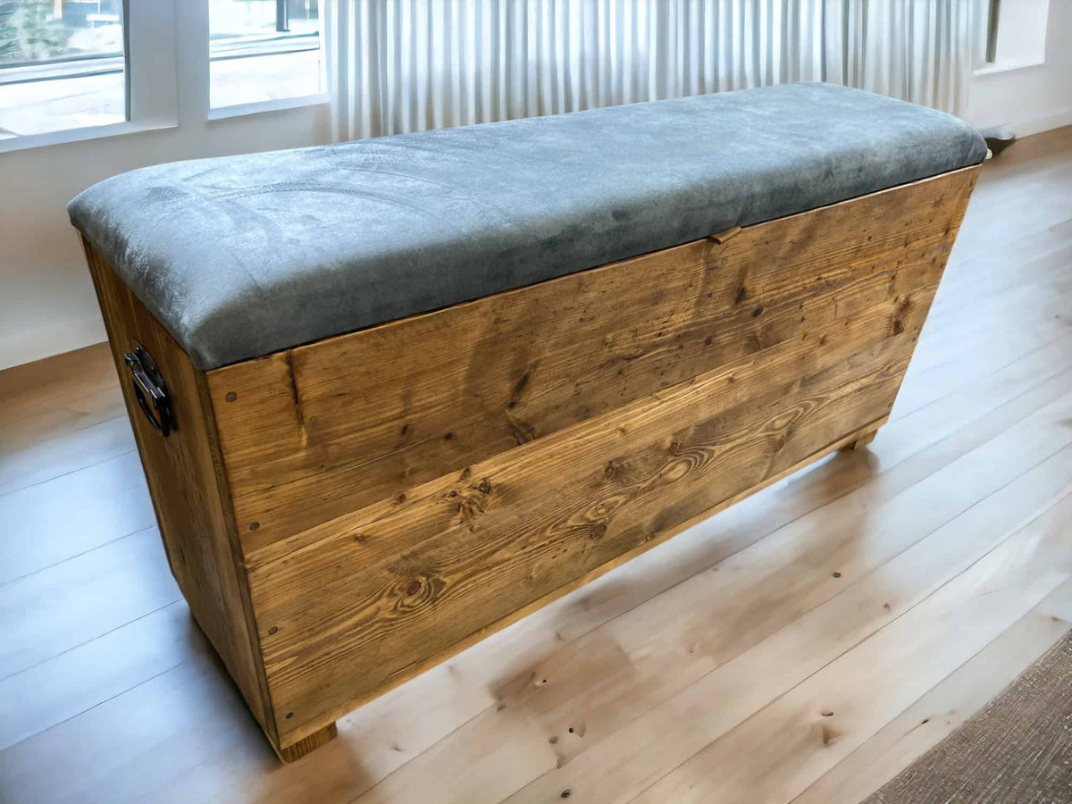Reclaimed-wood storage bench with a grey upholstered lift-up lid.