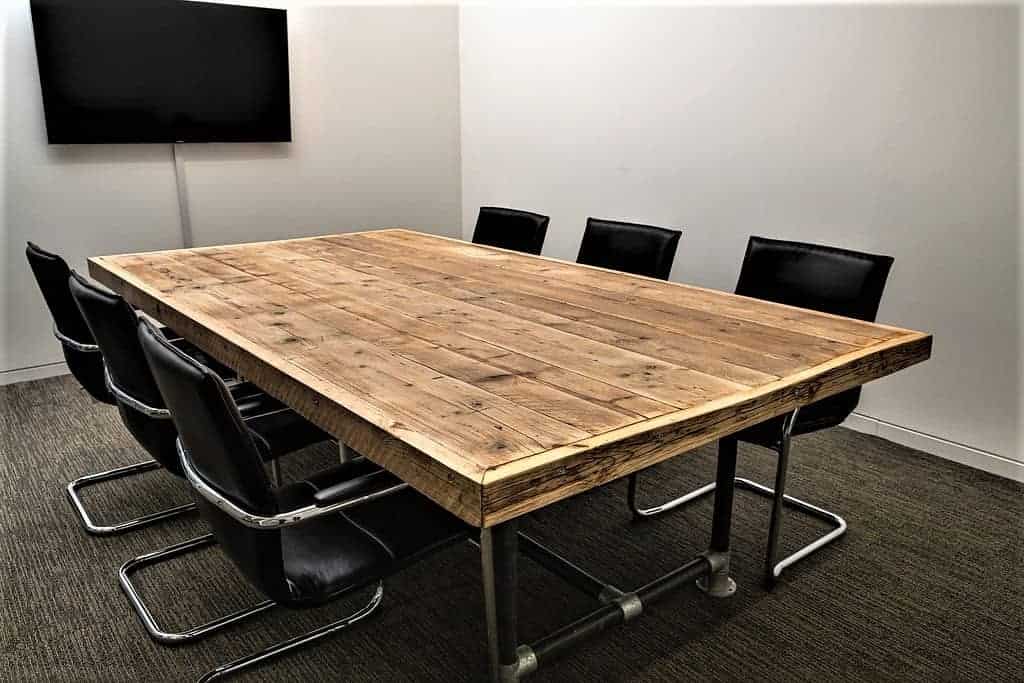 Long reclaimed-wood boardroom table with black steel legs