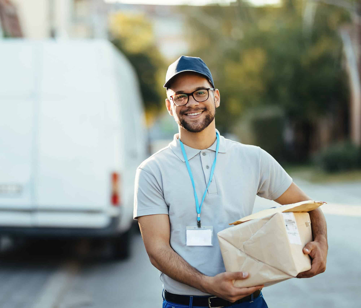 Courier carrying parcels beside a delivery van
