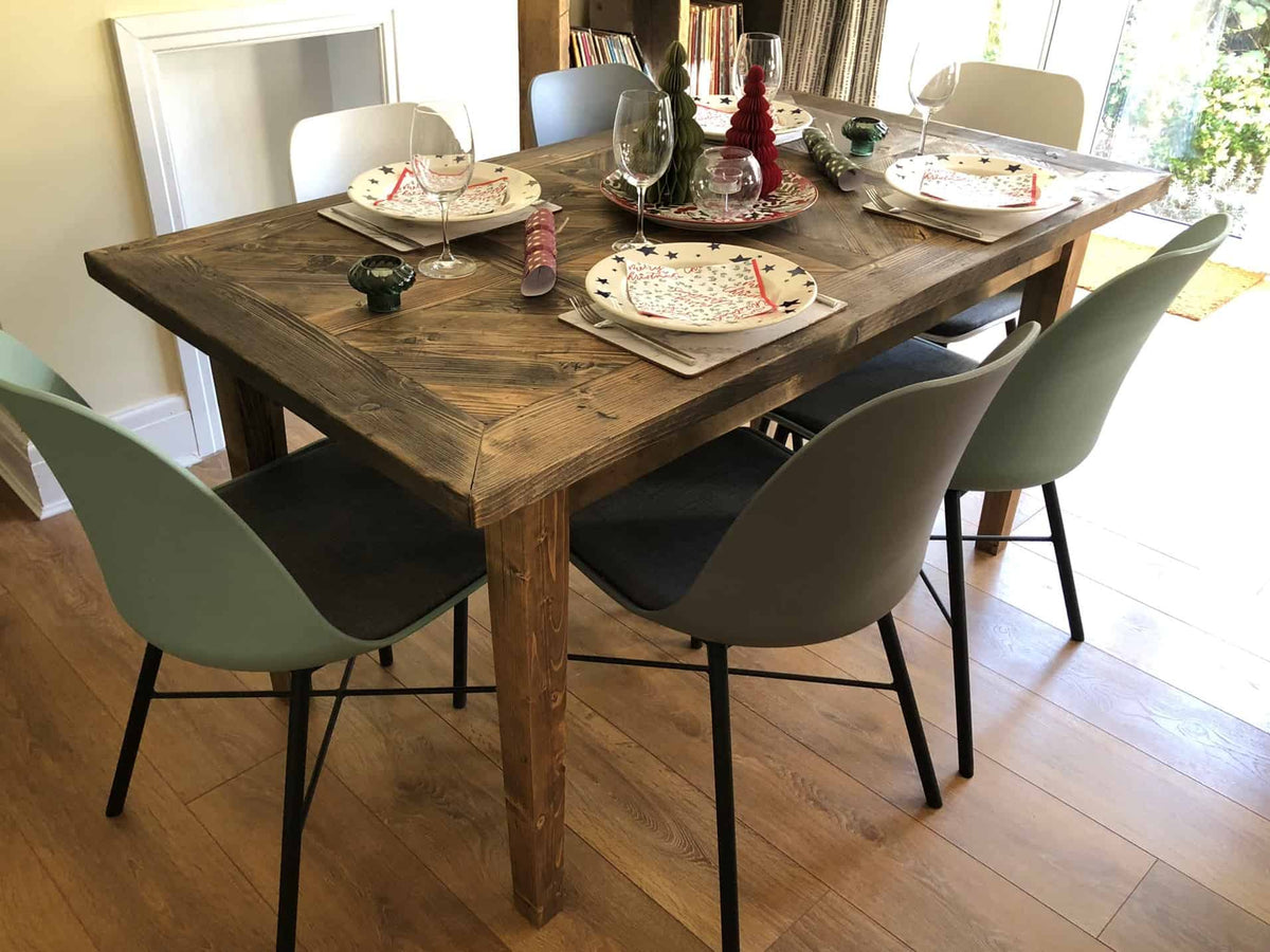 Dark-stained reclaimed-wood dining table set for six, with a framed plank top and matching straight wooden legs.