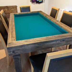 Reclaimed-wood gaming table with its dining top removed to reveal a recessed green playing surface.