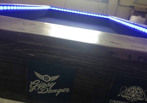 Gaming table playing area illuminated by LED lights.