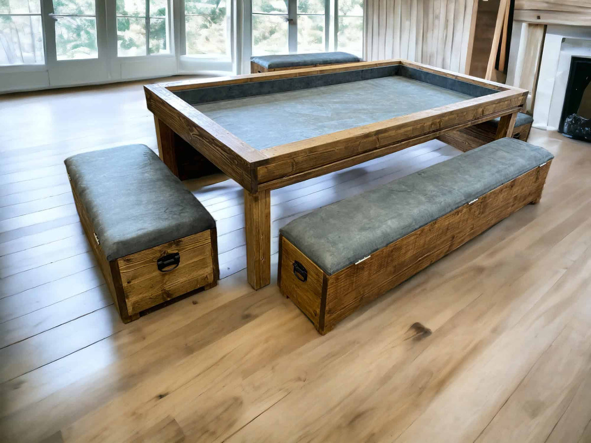 Reclaimed-wood gaming table with a grey play surface and two upholstered storage benches.