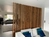 Wide natural-wood slat divider spanning an open-plan living room.