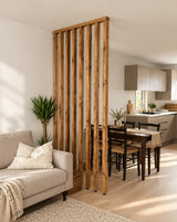 Shaw walnut-finished wooden slat room divider with a ceiling batten and adjustable feet between a Scandinavian living and dining area.