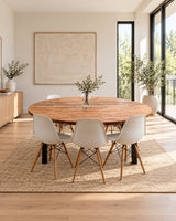Stockwood round reclaimed wood dining table in an amber finish, surrounded by white chairs in a bright Scandinavian dining room.