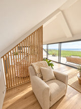 York wooden slat room divider with a slanted top following a pitched ceiling in a Scandinavian living room.